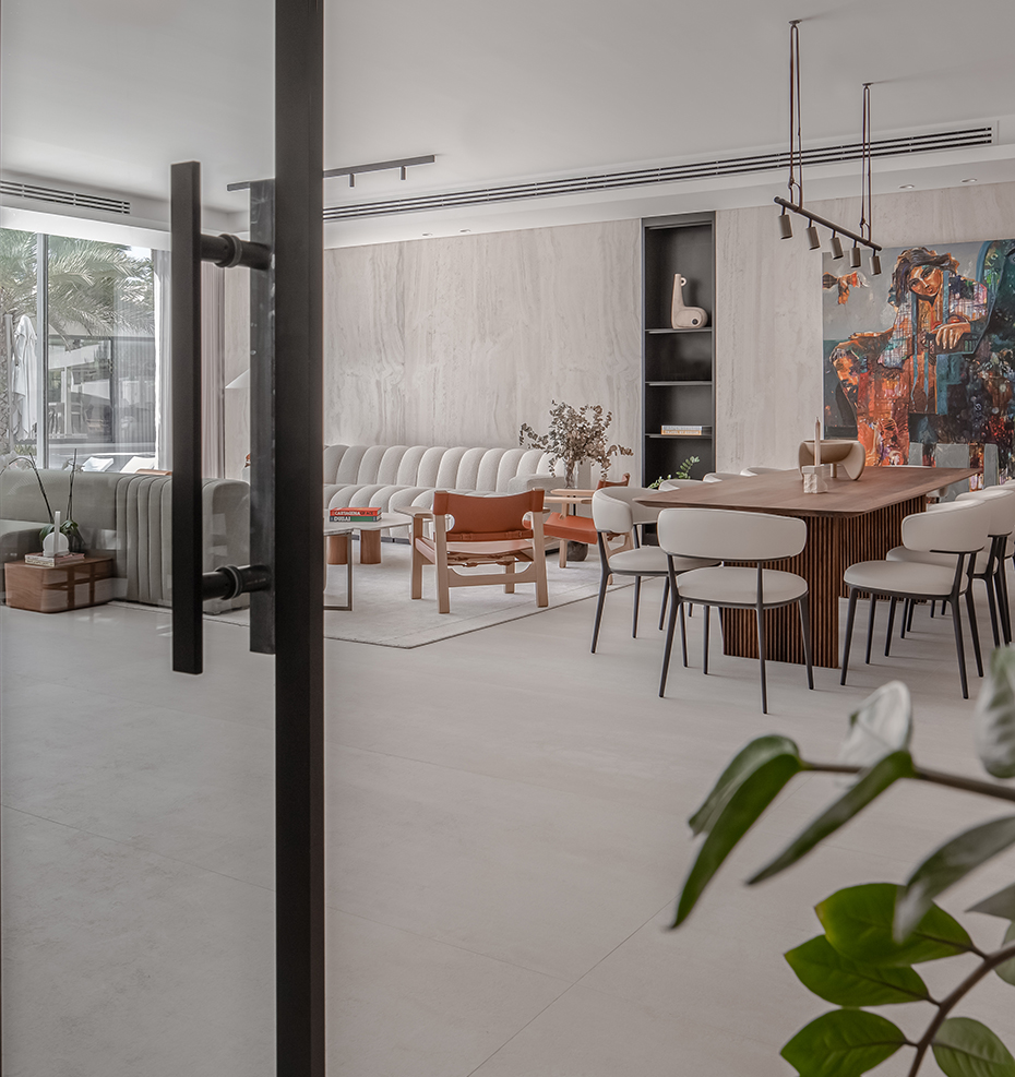 Minimalist luxury living and dining space after a full renovation in Dubai, featuring neutral tones, an open layout, and natural light.