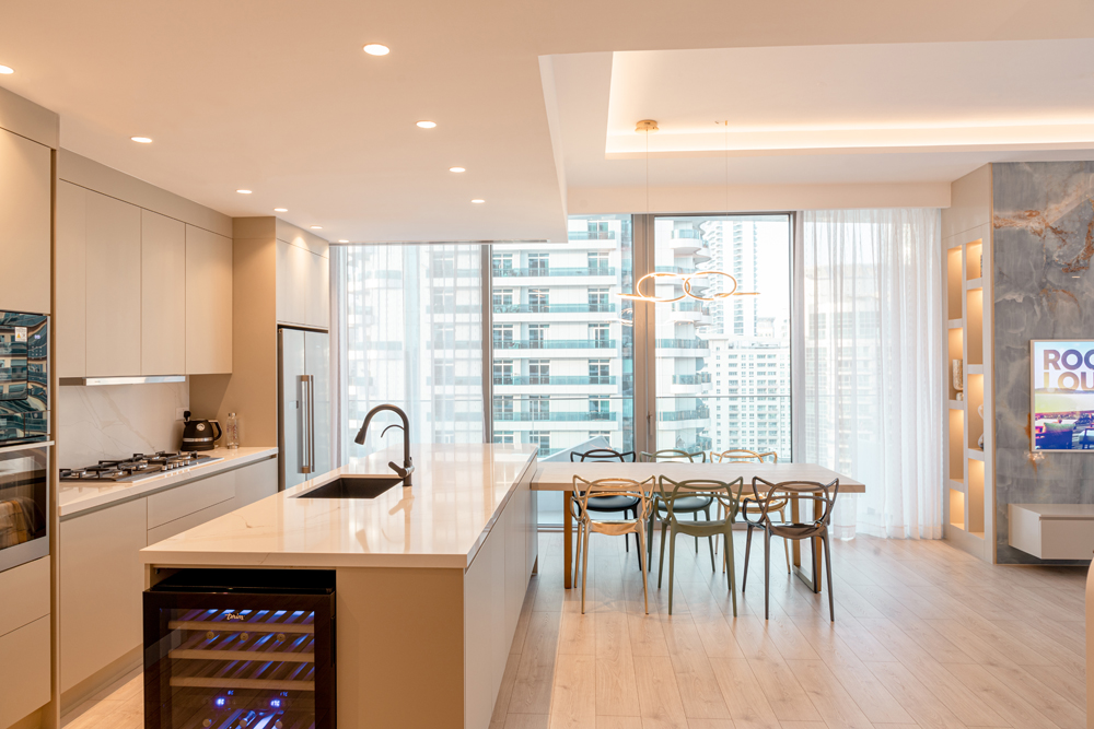 Minimalist interior design of kitchen and dining room in Stella Maris Apartment by Smart Renovation featuring seamless tech integration