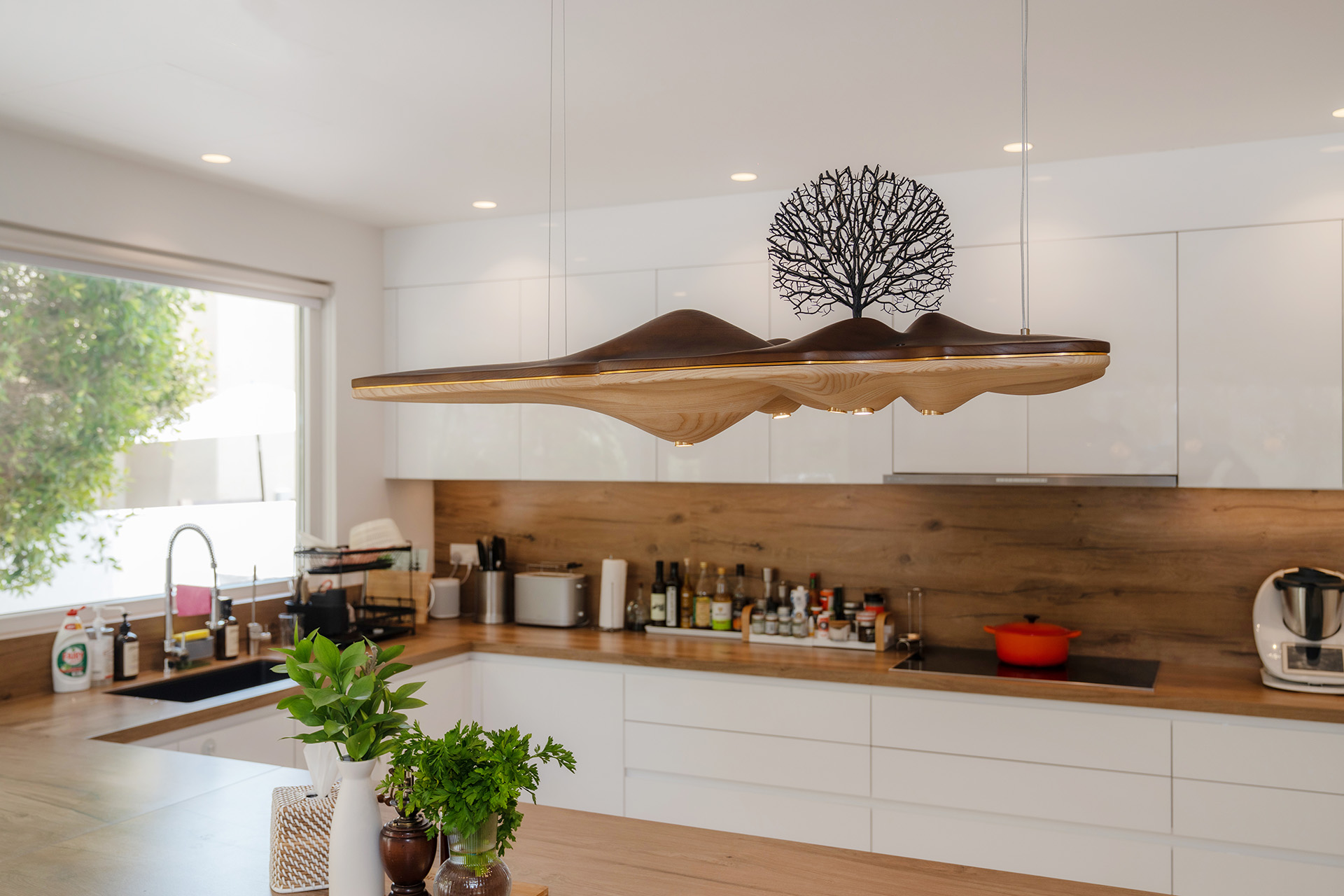 Villa Laura kitchen by Smart Renovation, showcasing unique and custom chandelier lighting to achieve a cohesive design aesthetic.