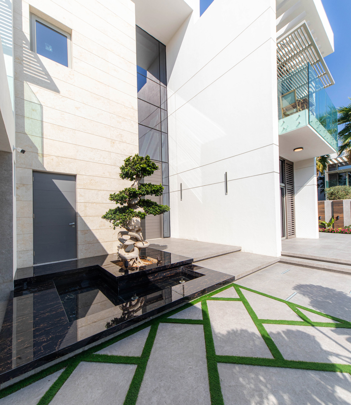 Spacious outdoor seating and entertainment area with patterned hardscape and garden landscaping in Dubai villa.