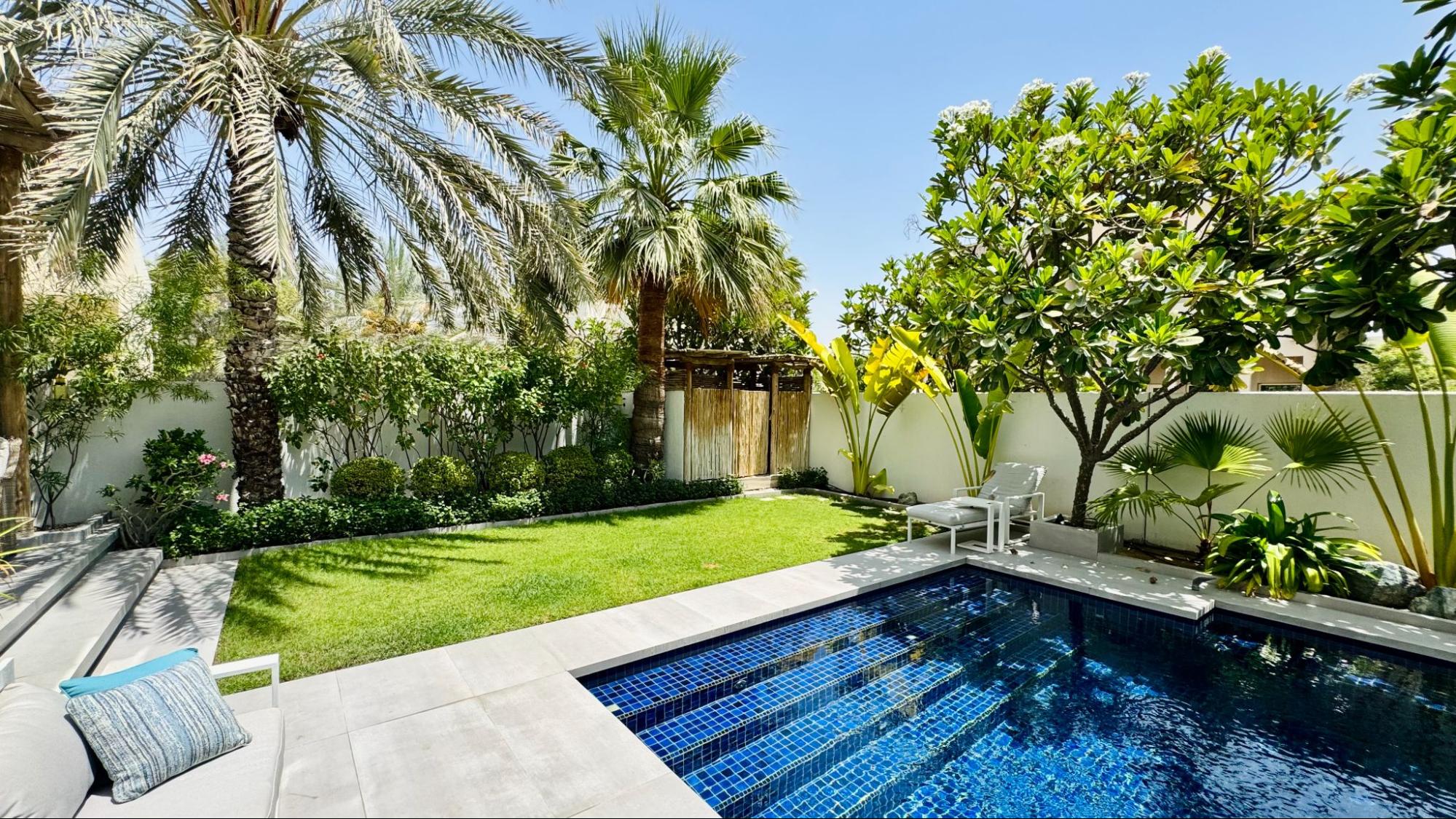 Luxury garden design by Smart Renovation for Casa Porto Cervo featuring tropical planting, palm trees, and a private pool.