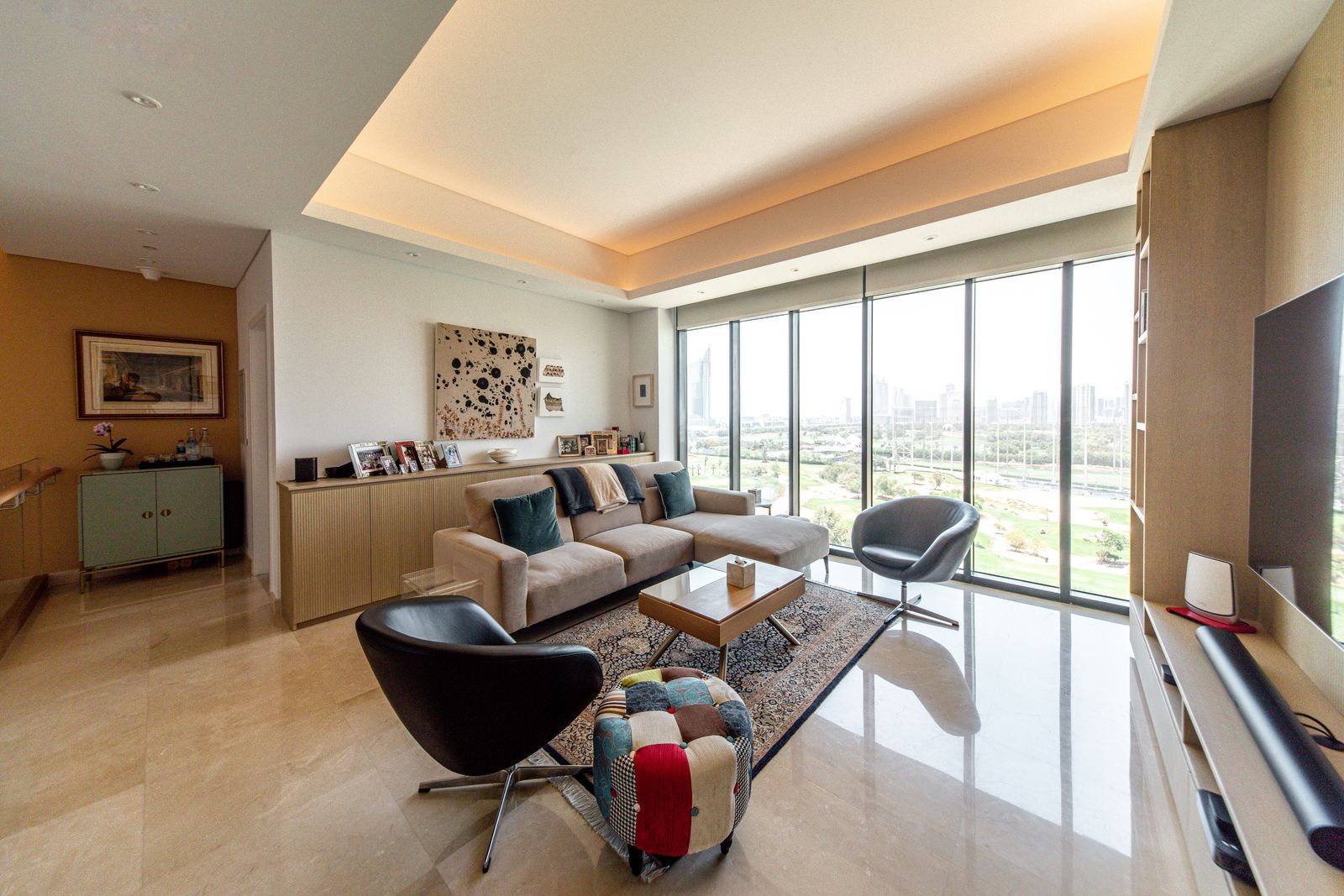 Stylish apartment upgrade in Dubai featuring a cosy lounge with elegant lighting and sweeping floor-to-ceiling windows.